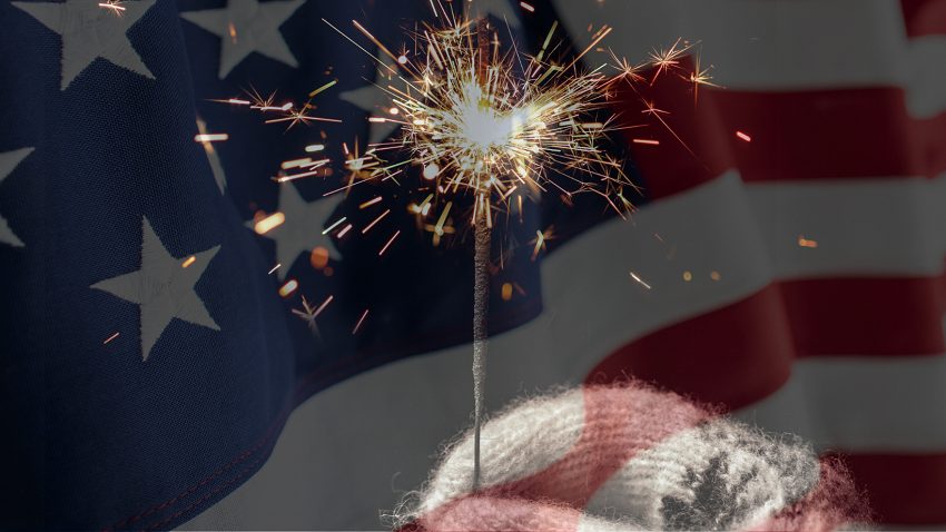 US flag and hand holding sparkler