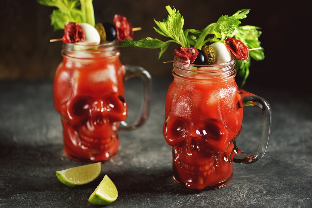 Herradura Tequila Bloody Maria in a skull mug garnished with lettuce, celery, and a gourmet pick.