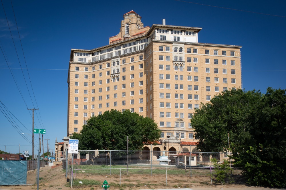 The towering, abandoned edifice of The Baker Hotel, looming under a dusky Texas sunset.