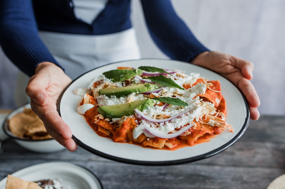 Mexican,Woman,Hands,Preparing,Chilaquiles,With,Red,Sauce,And,Eating