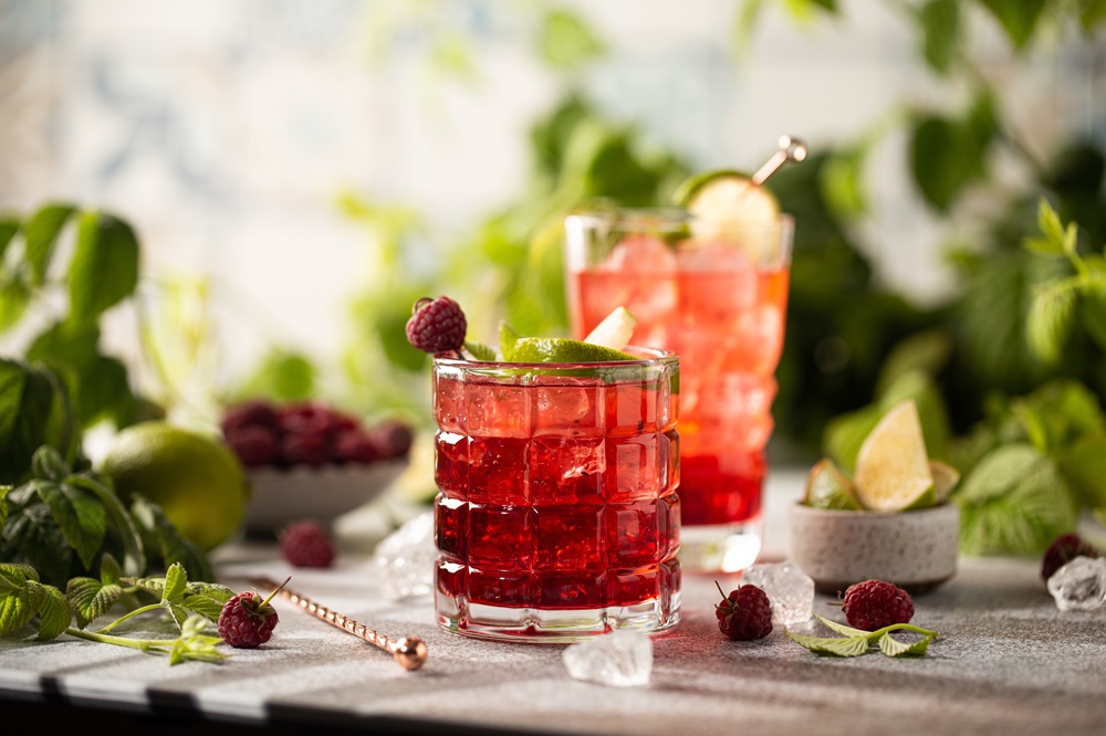 Raspberry,Cocktail,With,Lime,mint,ice,Cubes,And,Fresh,Berries,On,Grey